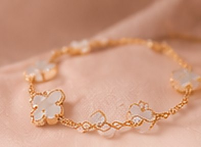 Gold chain bracelet with mother-of-pearl clover charms